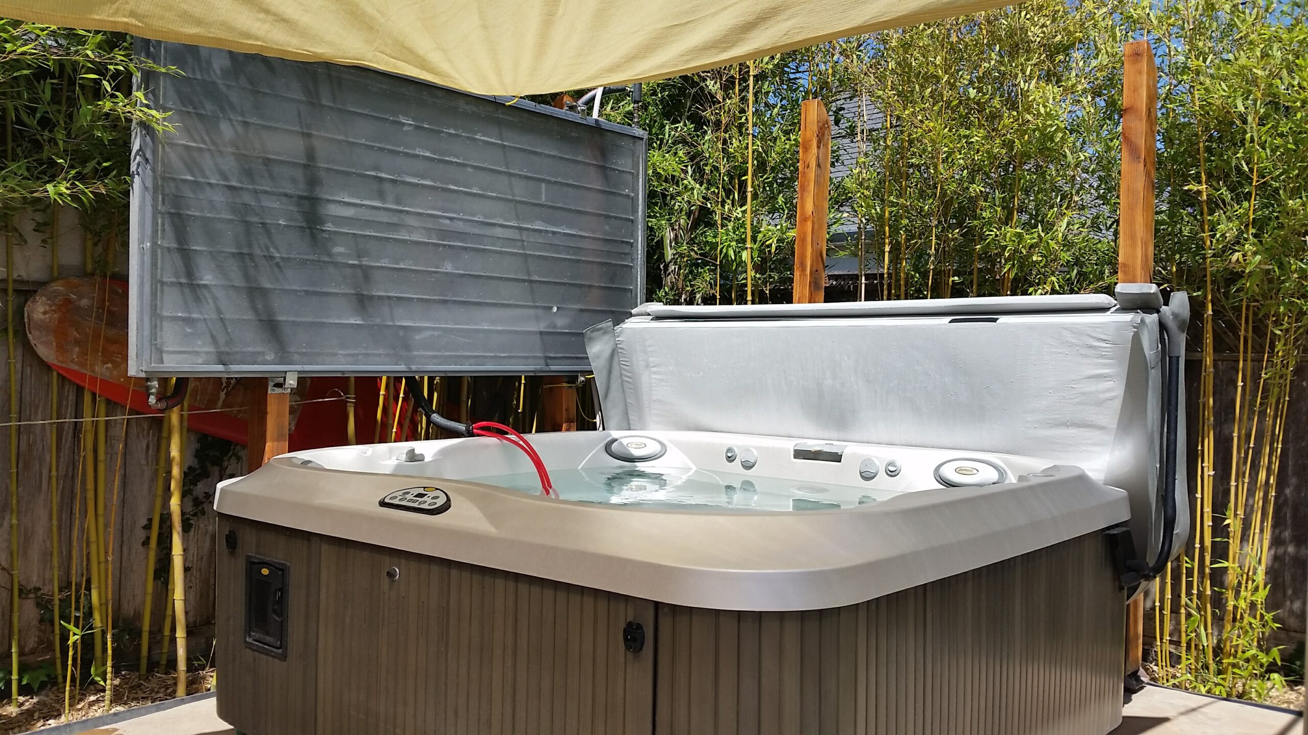 A flat plate solar collector mounted above a hot tub in order to drain back into the tub when not pumping