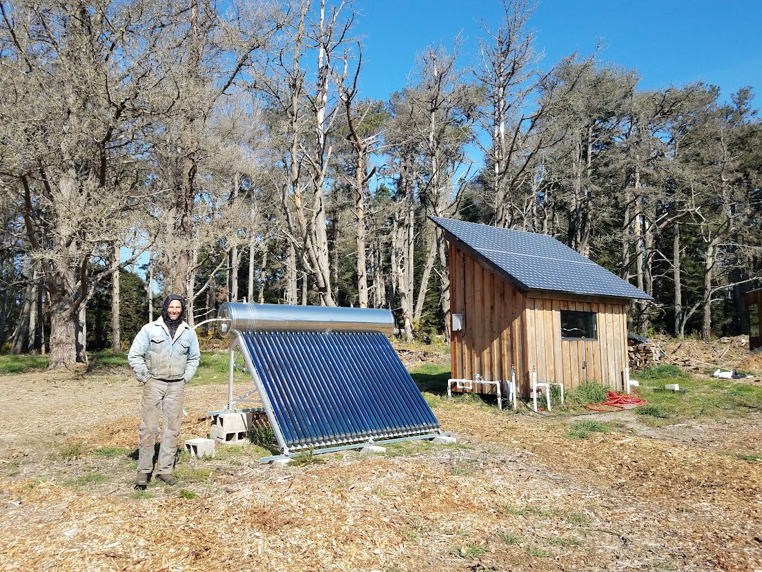 Sunbank solar water heater off-grid ground mounted next to solar panel system